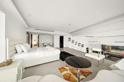 a white bedroom with a large bed and a table at Elegant 2BR with Burj Views, Pool, Gym, and Quick Metro Access in Dubai