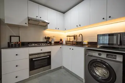 a kitchen with a washing machine and a microwave at Dubai Marina - 1 BHK Unique Apartment in Dubai
