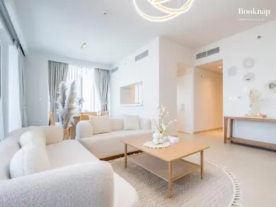a living room with white furniture and a coffee table at Lavish 3BR Apartment with Assistant Room in Habour Gate Tower in Dubai