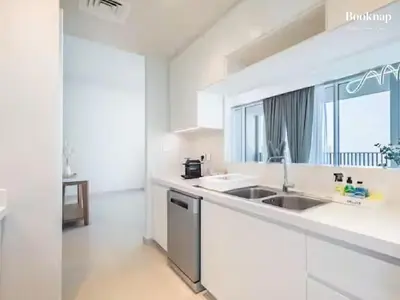 a white kitchen with a sink and a window at Lavish 3BR Apartment with Assistant Room in Habour Gate Tower in Dubai