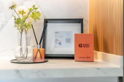 a table with a book and vases and a picture at GuestReady - Mesmerizing Marina views at Iris Blue in Dubai