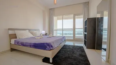 a bedroom with a bed and a large window at April OFFER Huge 1BKH 4people & high floor in Dubai