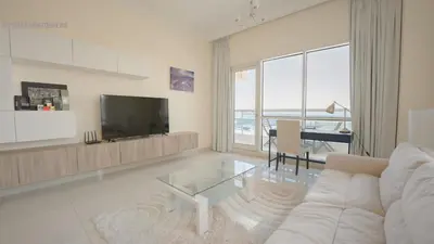 a living room with a white couch and a television at April OFFER Huge 1BKH 4people & high floor in Dubai