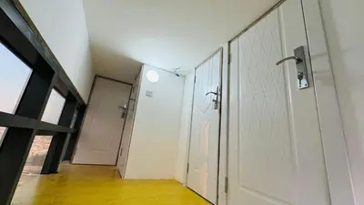 a hallway with a white door and a room with wood floors at Elegant Guesthouse in Business Bay in Dubai