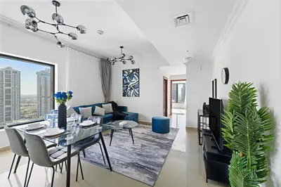 a living room with a table and a blue couch at Time Place Near Metro and Mall in Dubai