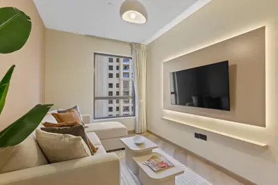 a living room with a couch and a tv at Beachside Home on JBR Walk with modern interiors in Dubai