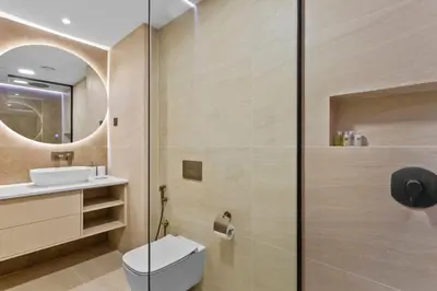 a bathroom with a shower and a toilet and a sink at Beachside Home on JBR Walk with modern interiors in Dubai