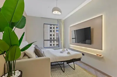a hotel room with a bed and a tv at Beachside Home on JBR Walk with modern interiors in Dubai