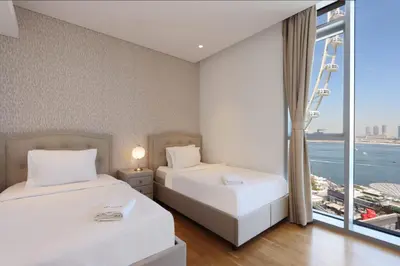 two beds in a room with a large window at Livbnb - Ain Dubai Panorama, 3BR with Maid's Room in Dubai