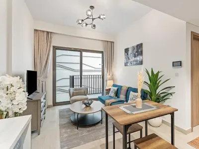 a living room with a couch and a table at Cozy Stay 1BR in Azizi Pearl in Dubai