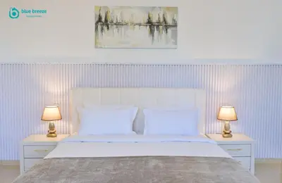 a bedroom with a white bed with two lamps at Blue Breeze - Elegant 3BR Apt with Panoramic Marina Views in JBR in Dubai