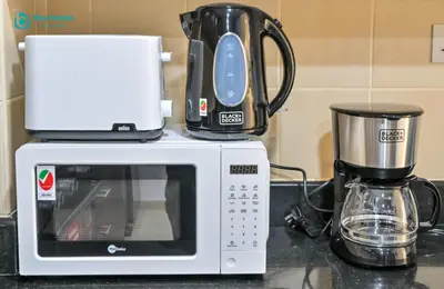 a coffee maker and a microwave on a counter at Blue Breeze - Elegant 3BR Apt with Panoramic Marina Views in JBR in Dubai