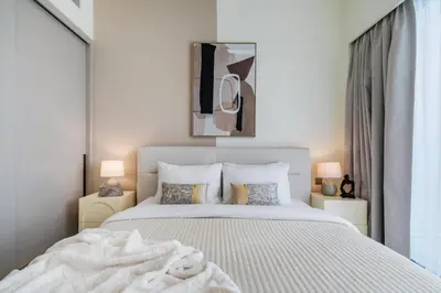 a bedroom with a large white bed and two lamps at The Smart Concierge - Signature Grande in Dubai