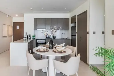a kitchen and dining room with a white table and chairs at The Smart Concierge - Signature Grande in Dubai