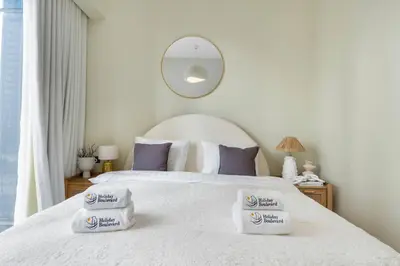 a bedroom with a white bed with two pillows on it at BLVD - Steps from Dubai mall and Dancing Fountain in Dubai