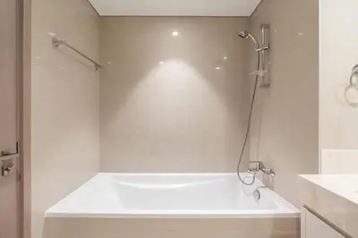 a white bath tub in a bathroom with a shower at BLVD - Steps from Dubai mall and Dancing Fountain in Dubai