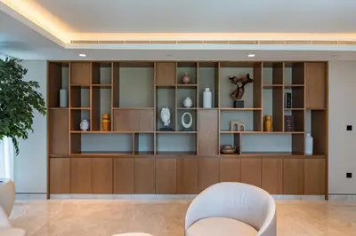 a living room with a large wooden book shelf at BLVD - Steps from Dubai mall and Dancing Fountain in Dubai