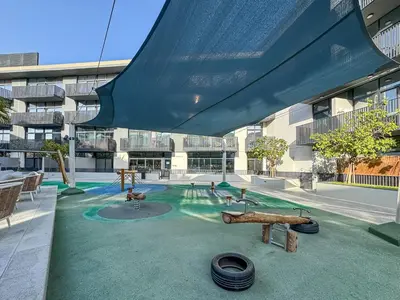 a building with a pool with a playground in it at Stylish 1BR APT with Gym, Pool & Private Parking in Dubai