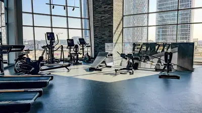 a gym with treadmills and exercise equipment in a building at Full Burj Khalifa & Canal View I 7 Mins to Dubai Mall I Exclusive 2BHK For Up to 6 People in Dubai