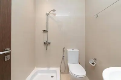 a white bathroom with a toilet and a sink at Holiday Boulevard - Luxury 3BR Penthouse with Burj Khalifa and Creek Views in Dubai