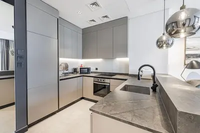a kitchen with stainless steel appliances and a sink at Waves - Stunning 1BR with Huge Terrace & Scenic Views in Dubai