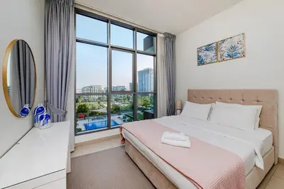 a bedroom with a bed and a large window at Apartment in Dubai Hills Park Acacia A in Dubai
