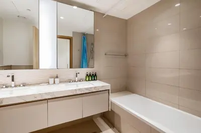 a bathroom with two sinks and a tub and a mirror at Apartment in Dubai Hills Park Acacia A in Dubai