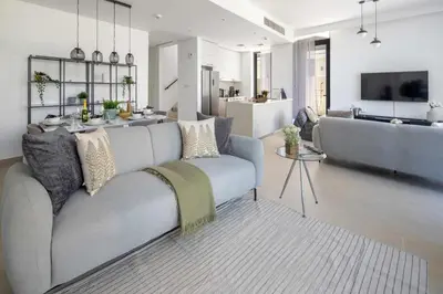 a living room with a couch and a kitchen at Frank Porter - Club Villas in Dubai