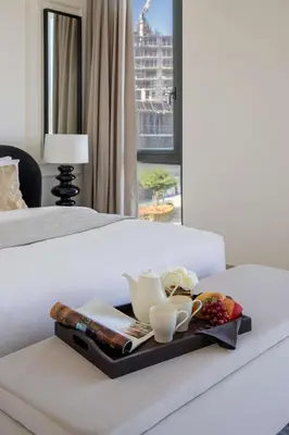 a tray with a tea pot and cups on a bed at Frank Porter - Club Villas in Dubai