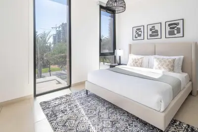 a bedroom with a white bed and a large window at Frank Porter - Club Villas in Dubai