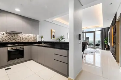 a kitchen with black and white appliances and a dining room at Sky-High 2BR - Infinity Pool & Burj Khalifa Views in Dubai