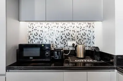 a kitchen counter with a microwave and a coffee maker at Sky-High 2BR - Infinity Pool & Burj Khalifa Views in Dubai