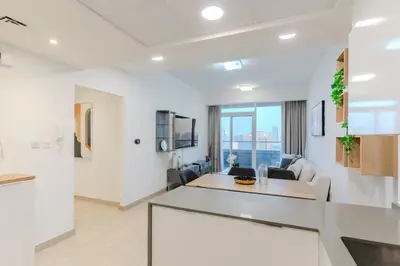 a living room with white walls and a table at Spacious l Opened View l Fits 4 in Dubai