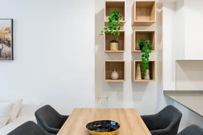 a dining room with a wooden table and chairs at Spacious l Opened View l Fits 4 in Dubai