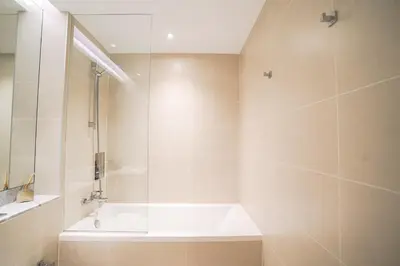 a white bathroom with a tub and a shower at Sea View l Port De LaMer l Next to Beach l Perfect for 4 in Dubai