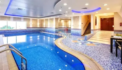 a swimming pool in a hotel with blue tile at Serene 2BR with Iconic Palm Jumeirah Views, Dubai Marina by Deluxe Holiday Homes in Dubai