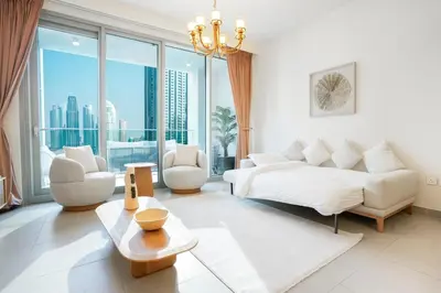 a living room with a couch and a large window at FIRST CLASS 3BR Burj Khalifa & Fountain view in Dubai
