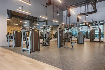 a gym with rows of exercise equipment in a room at FIRST CLASS 3BR Burj Khalifa & Fountain view in Dubai