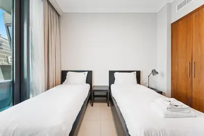 two beds in a room with a window at 3BR Family abode with Iconic Burj Khalifa view in Dubai