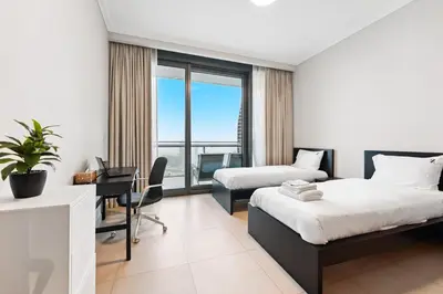 a hotel room with two beds and a desk with a computer at 3BR Family abode with Iconic Burj Khalifa view in Dubai