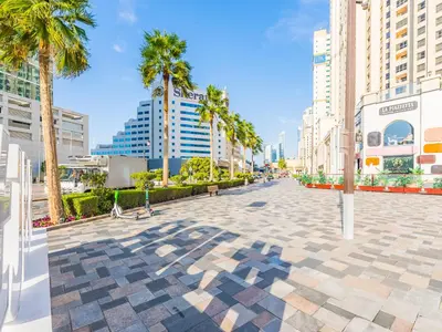 a street in a city with palm trees and buildings at The 'Mallorca' Condo - JBR Beachfront Stay in Dubai
