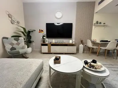 a living room with a couch and a tv at Deluxe 1BHK Apt in JVC, Self check in ! in Dubai
