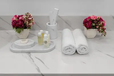 a white counter with flowers and towels and flowers at Spacious 2BR with Pool & Private Beach Access in Dubai