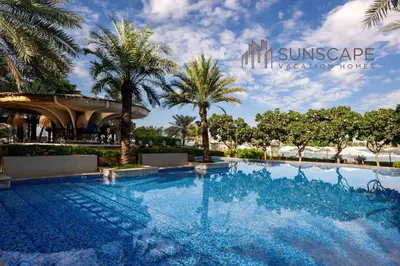 a swimming pool in a resort with palm trees at Spacious 2BR with Pool & Private Beach Access in Dubai