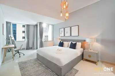 a bedroom with a large white bed and a desk at Fascinating Ocean Views in a One Bedroom in Dubai