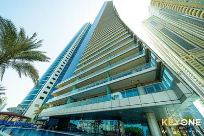 a tall building with a palm tree in front of it at Fascinating Ocean Views in a One Bedroom in Dubai