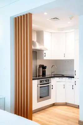 a kitchen with white cabinets and a stove top oven at Modern Studio I Boulevard View I Downtown Dubai in Dubai