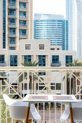 a table and chairs on a balcony with buildings at Modern Studio I Boulevard View I Downtown Dubai in Dubai