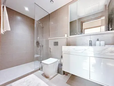 a bathroom with a toilet and a shower and a sink at Amazing 1 Bedroom in Burj Royale Downtown in Dubai