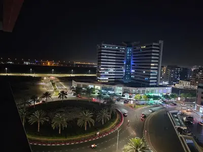 a city street at night with cars and buildings at Dubai Silicon Oasis Staycation in Dubai
